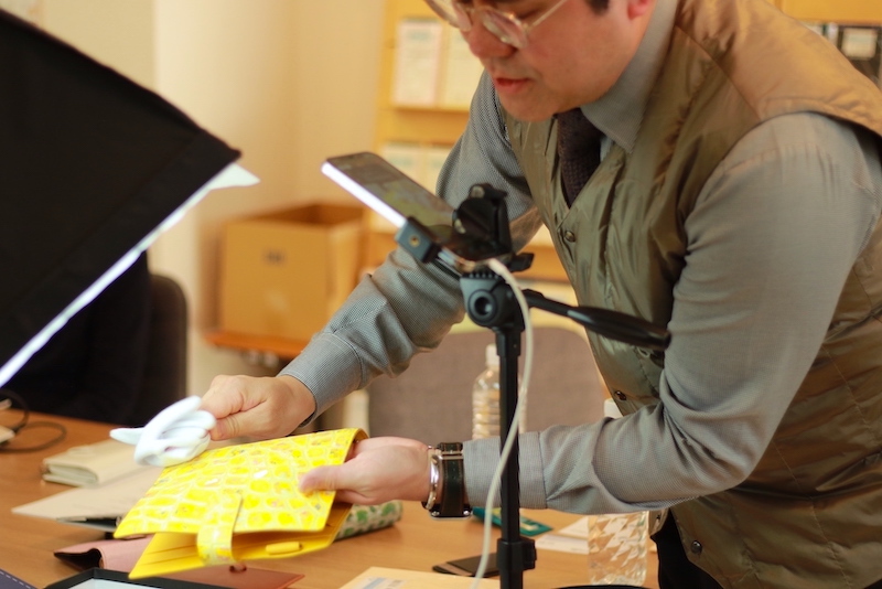 手帳カバーのメンテナンス方法を実演する向井さん